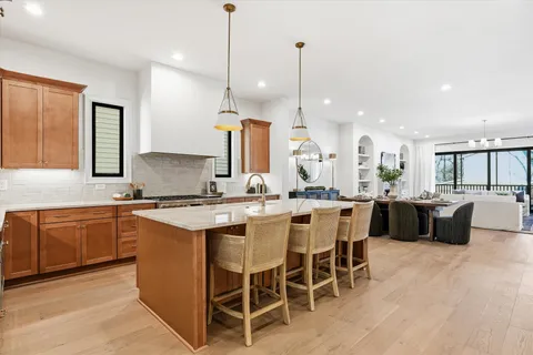 a kitchen with kitchen island granite countertop a sink a counter space appliances and cabinets
