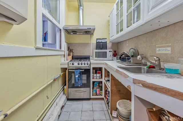 a kitchen with stainless steel appliances kitchen island granite countertop a stove and a large window