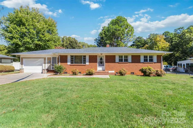 a view of a house with backyard and sitting area