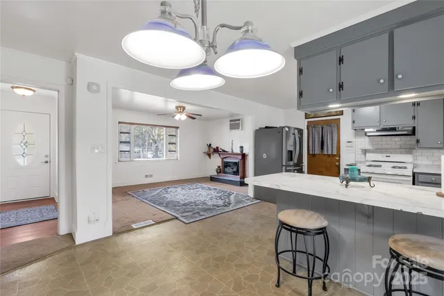 a kitchen with stainless steel appliances kitchen island granite countertop a table and chairs in it