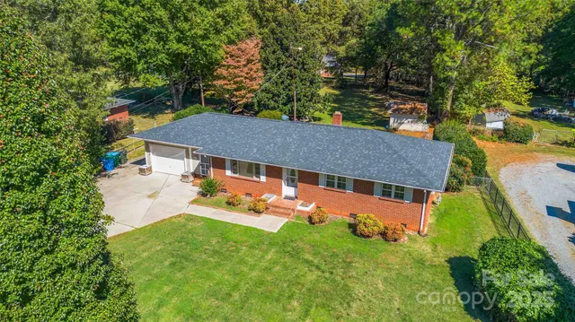 an aerial view of a house with backyard space and balcony