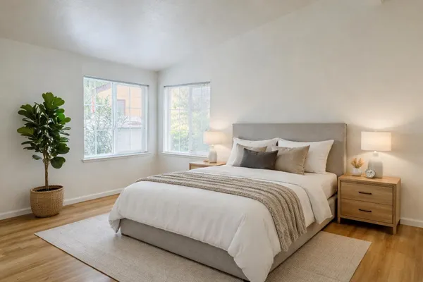 a bedroom with a bed a mirror and a potted plant