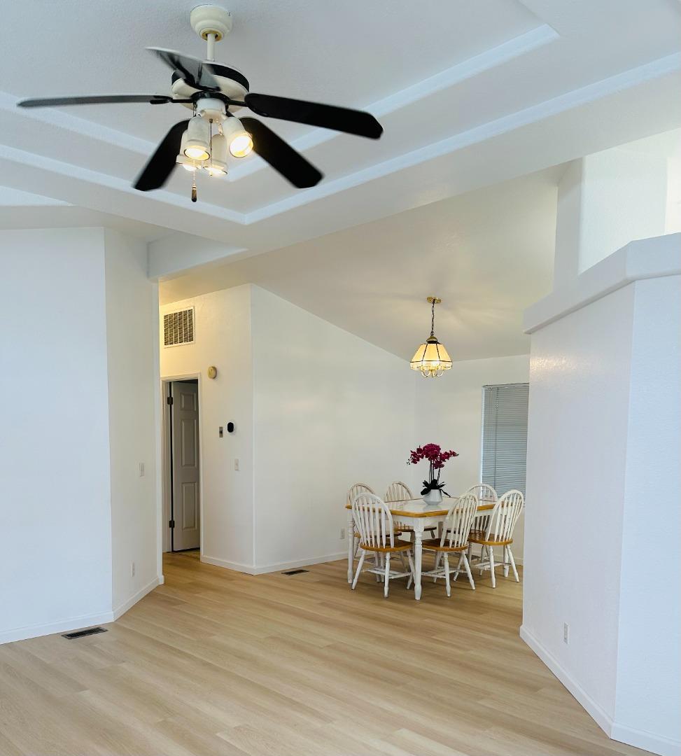 200 Ford Road, Unit 227 San Jose, CA 95138 - Photo 5 of 27 a dining room with wooden floor a chandelier a wooden table and chairs