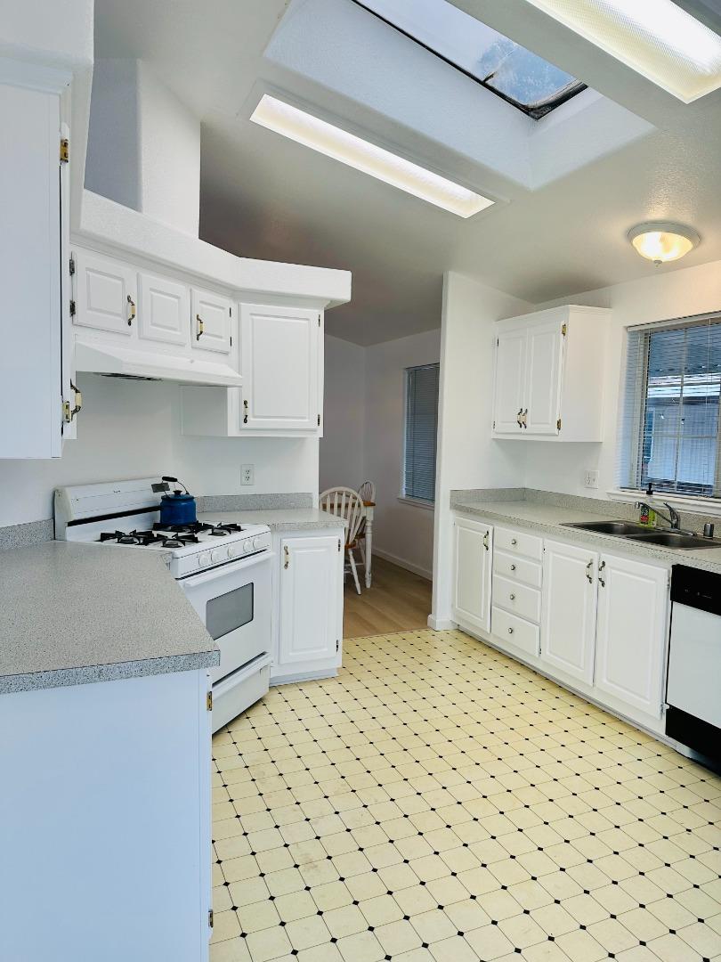 200 Ford Road, Unit 227 San Jose, CA 95138 - Photo 8 of 27 a kitchen with stainless steel appliances a sink a stove a refrigerator and white cabinets