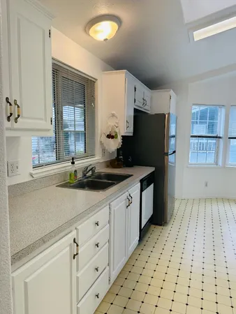 a kitchen with a sink a stove and cabinets