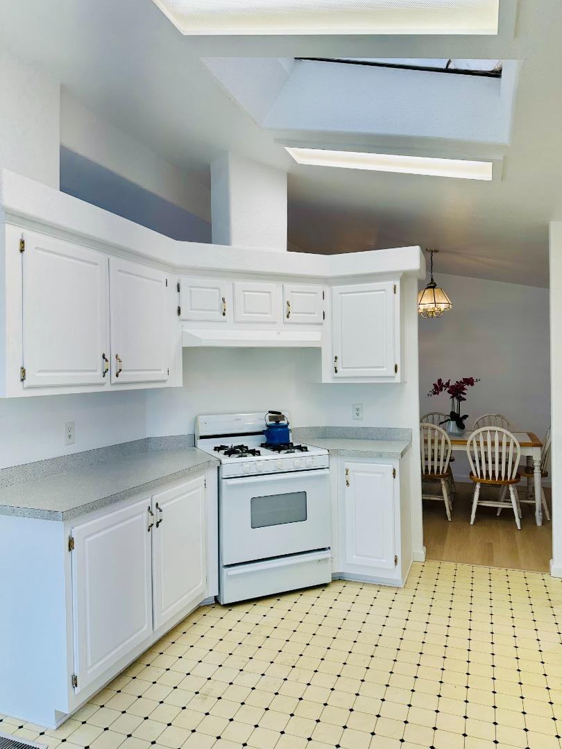 200 Ford Road, Unit 227 San Jose, CA 95138 - Photo 10 of 27 a kitchen with a sink a stove and white cabinets