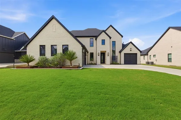 a front view of a house with a yard and green space