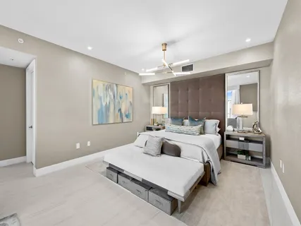 a bedroom with a large bed and a chandelier