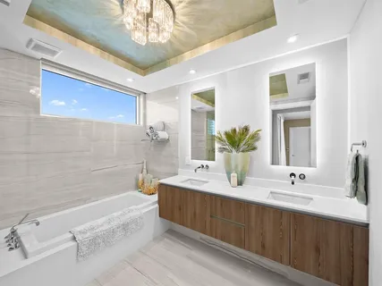 a spacious bathroom with a double vanity sink a mirror and a bathtub
