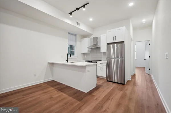 a kitchen with a refrigerator a white stove top oven and a refrigerator
