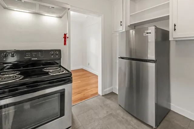 a view of a kitchen with a stove refrigerator and microwave