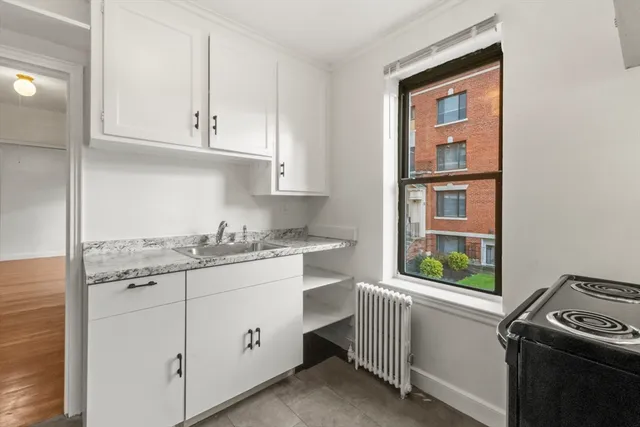 a kitchen with granite countertop white cabinets and white appliances