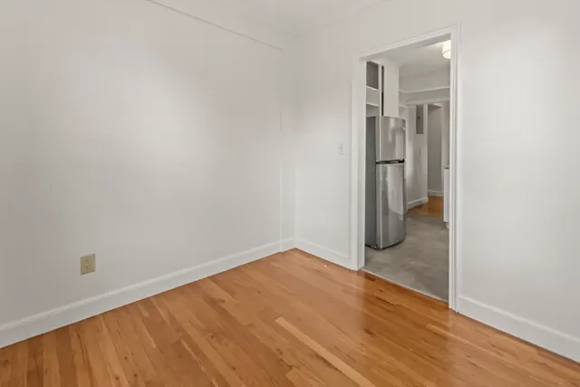 a view of a small space with wooden floor and a hallway