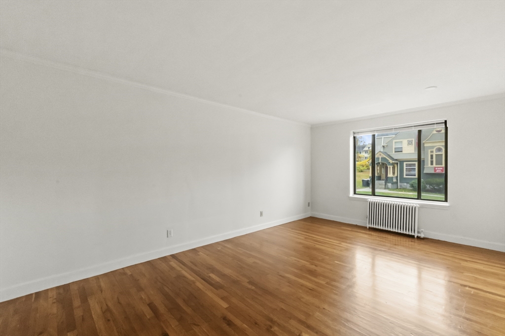 38-40 Cedar Street, Unit 141 Worcester, MA 01609 - Photo 20 of 26 an empty room with wooden floor and windows