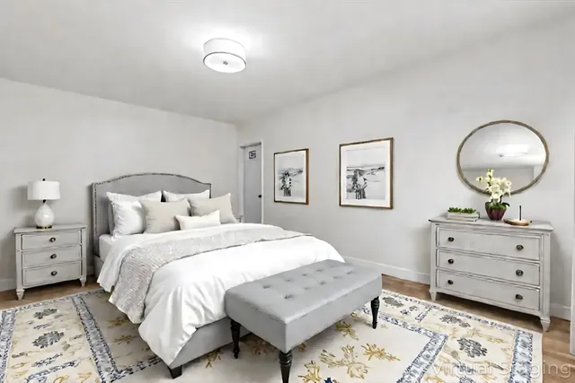a bedroom with a bed and a lamp on dresser