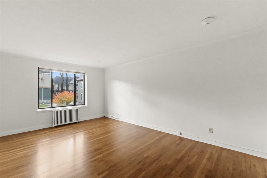 38-40 Cedar Street, Unit 141 Worcester, MA 01609 - Photo 21 of 26 an empty room with wooden floor and window