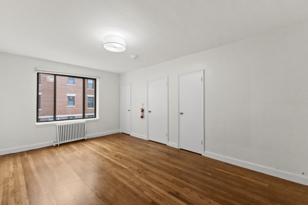 38-40 Cedar Street, Unit 141 Worcester, MA 01609 - Photo 7 of 26 a view of an empty room with window and wooden floor