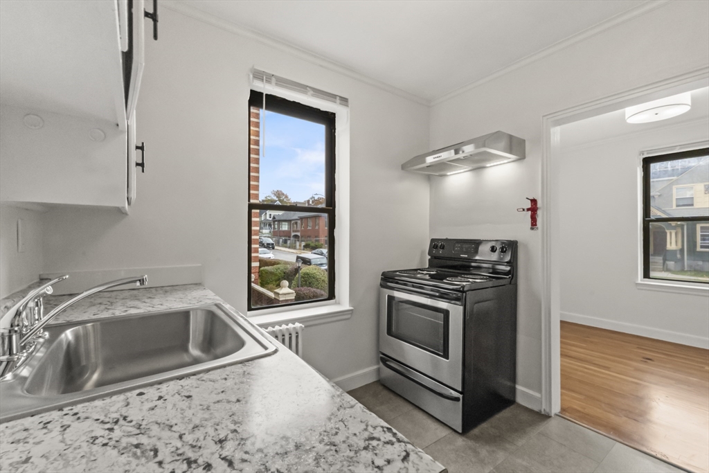 38-40 Cedar Street, Unit 141 Worcester, MA 01609 - Photo 10 of 26 a kitchen that has a sink cabinets appliances and a window