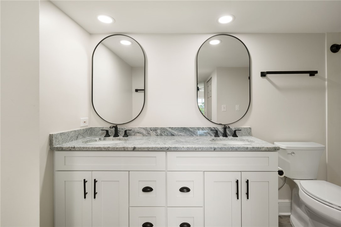 1180 Reef Road, Unit A20 Vero Beach, FL 32963 - Photo 15 of 32 a bathroom with a granite countertop double vanity sinks and a mirror
