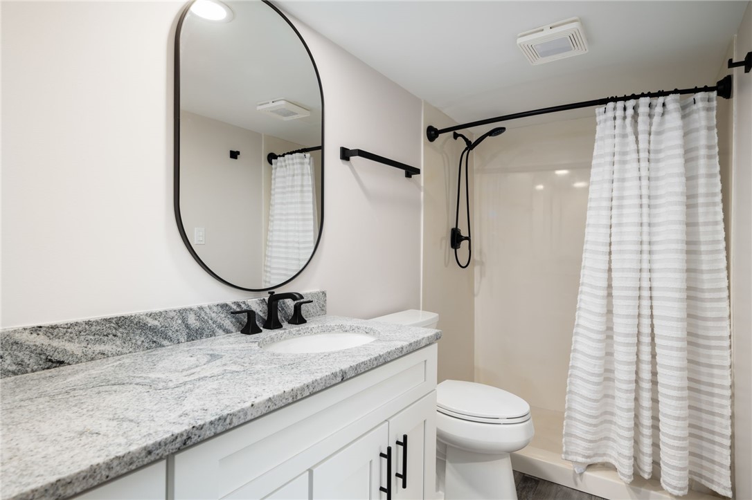 1180 Reef Road, Unit A20 Vero Beach, FL 32963 - Photo 16 of 32 a bathroom with a granite countertop sink toilet and a mirror