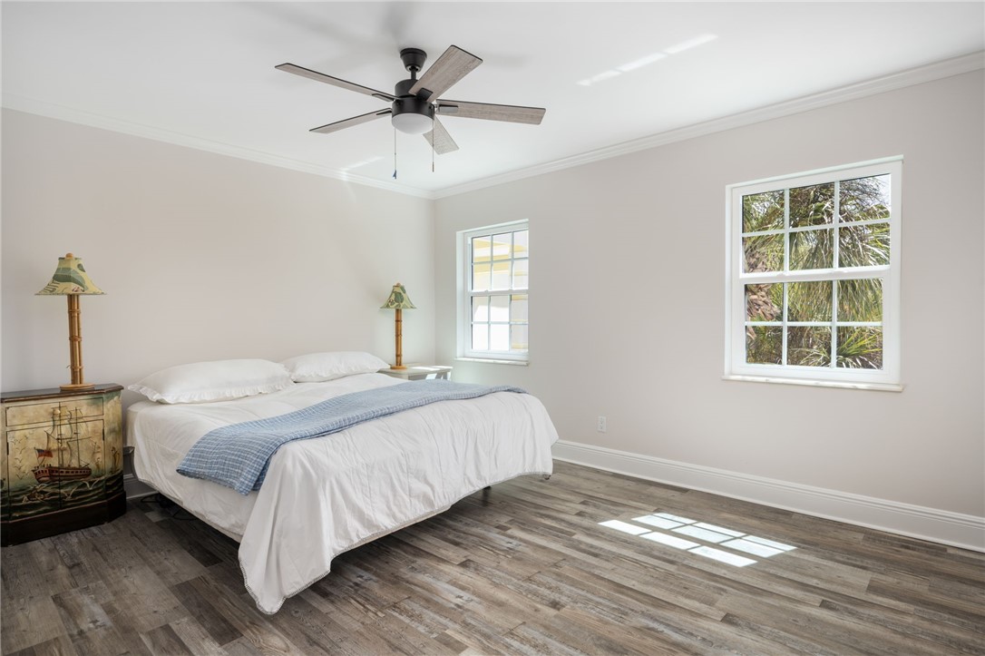 1180 Reef Road, Unit A20 Vero Beach, FL 32963 - Photo 17 of 32 a bedroom with a bed a chandelier and a window