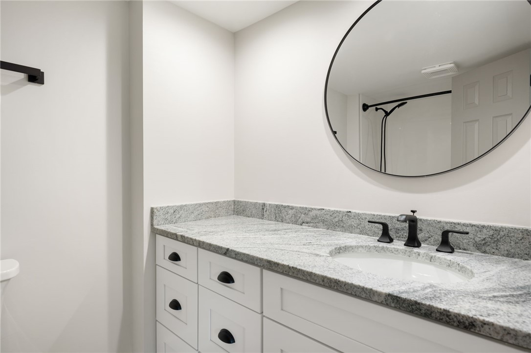 1180 Reef Road, Unit A20 Vero Beach, FL 32963 - Photo 18 of 32 a bathroom with a granite countertop sink and a mirror