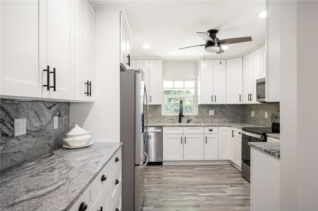 1180 Reef Road, Unit A20 Vero Beach, FL 32963 - Photo 8 of 32 a kitchen with stainless steel appliances kitchen island granite countertop a sink and cabinets