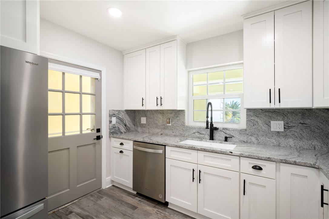 1180 Reef Road, Unit A20 Vero Beach, FL 32963 - Photo 10 of 32 a kitchen with granite countertop white cabinets and a window