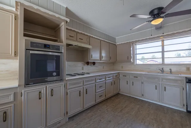 a kitchen with granite countertop a sink stainless steel appliances and cabinets