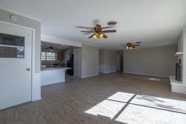 a view of an empty room and kitchen view