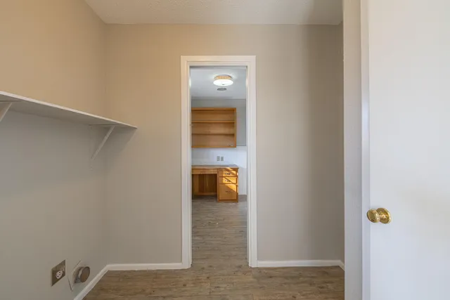a view of a hallway with wooden floor