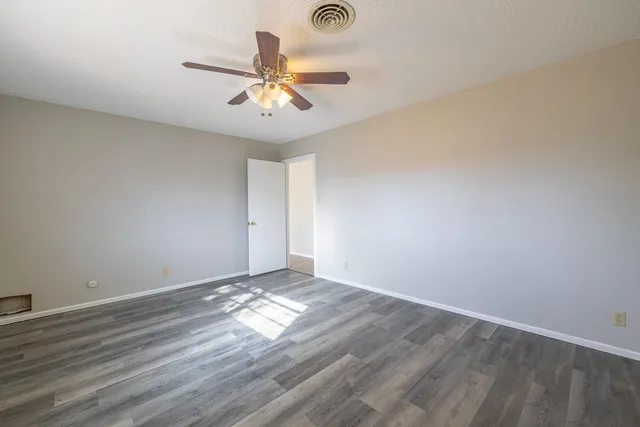a view of a big room with wooden floor and windows in a room
