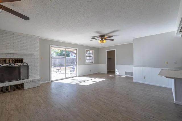 a view of an empty room with a window and fireplace