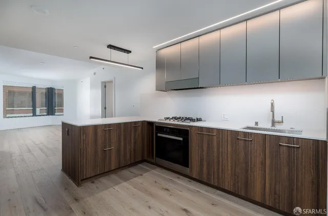 a kitchen with stainless steel appliances granite countertop a stove a sink and a microwave