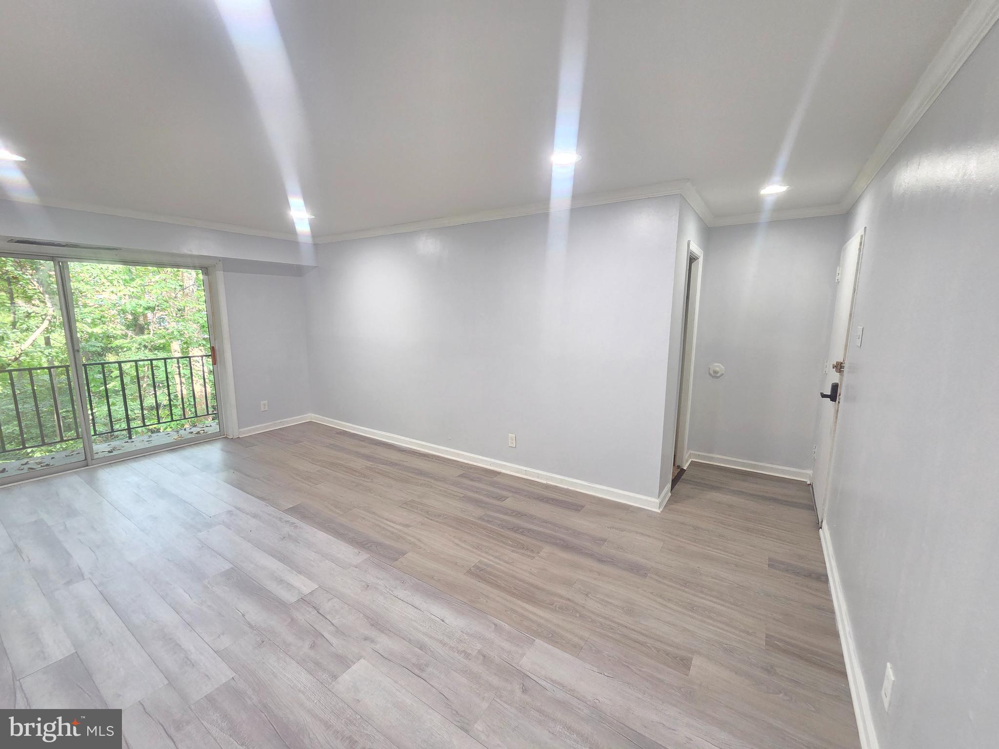12658 Dara Drive, Unit 102 Woodbridge, VA 22192 - Photo 3 of 19 an empty room with wooden floor and windows
