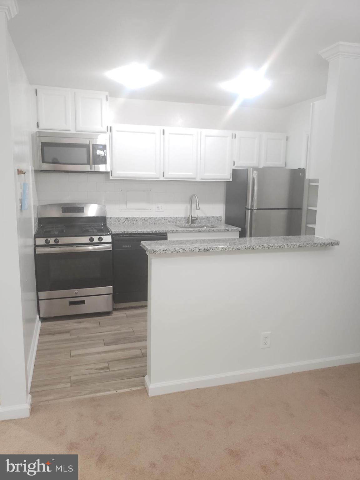 12658 Dara Drive, Unit 102 Woodbridge, VA 22192 - Photo 9 of 19 a kitchen with stainless steel appliances granite countertop a sink and a stove