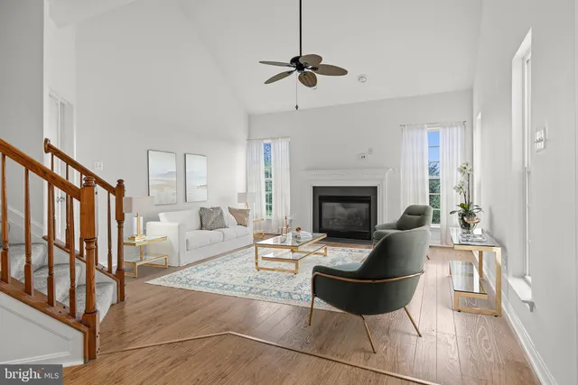 a living room with furniture floor to ceiling window and a fireplace