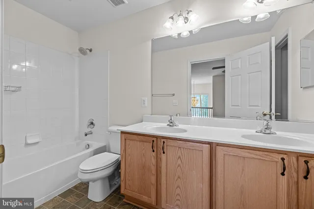 a bathroom with a toilet a sink a tub and a mirror