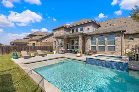 a view of a house with swimming pool and sitting area