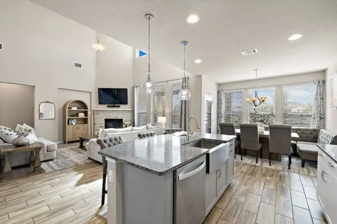 a open kitchen with stainless steel appliances granite countertop a lot of cabinets a sink dishwasher and a stove with wooden floor