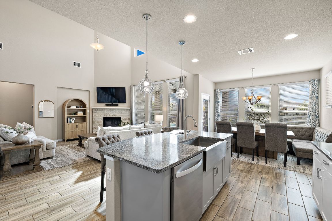 504 Leon Loop Liberty Hill, TX 78642 - Photo 11 of 40 a open kitchen with stainless steel appliances granite countertop a lot of cabinets a sink dishwasher and a stove with wooden floor