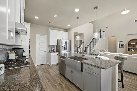 a kitchen with stainless steel appliances granite countertop a sink stove and refrigerator