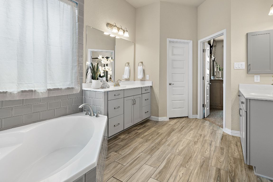 504 Leon Loop Liberty Hill, TX 78642 - Photo 19 of 40 a spacious bathroom with a tub sink and mirror