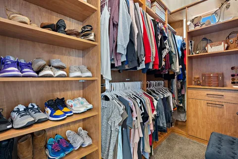 a view of walk in closet with clothes and shoes