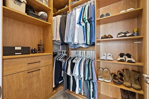 a view of walk in closet with clothes and shoes