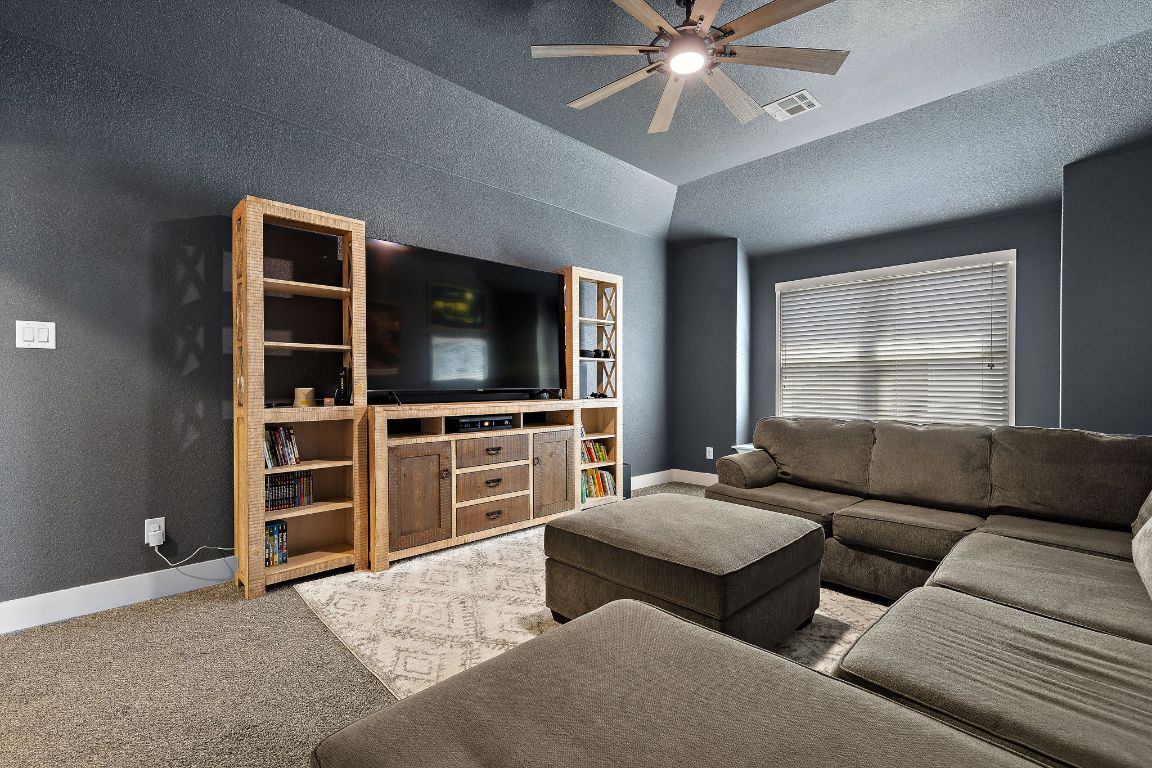 504 Leon Loop Liberty Hill, TX 78642 - Photo 30 of 40 a living room with furniture and a flat screen tv