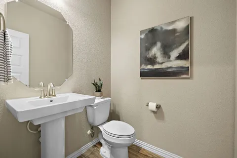 a bathroom with a toilet a sink and mirror