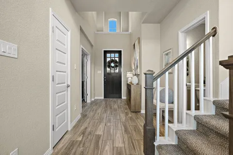 a view of a livingroom with wooden floor and stairs