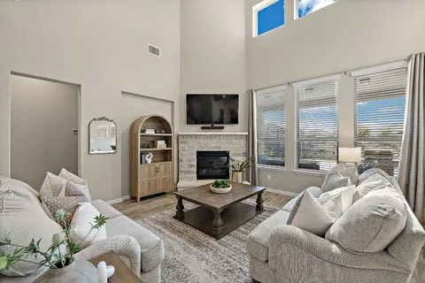 a living room with furniture a flat screen tv and a fireplace