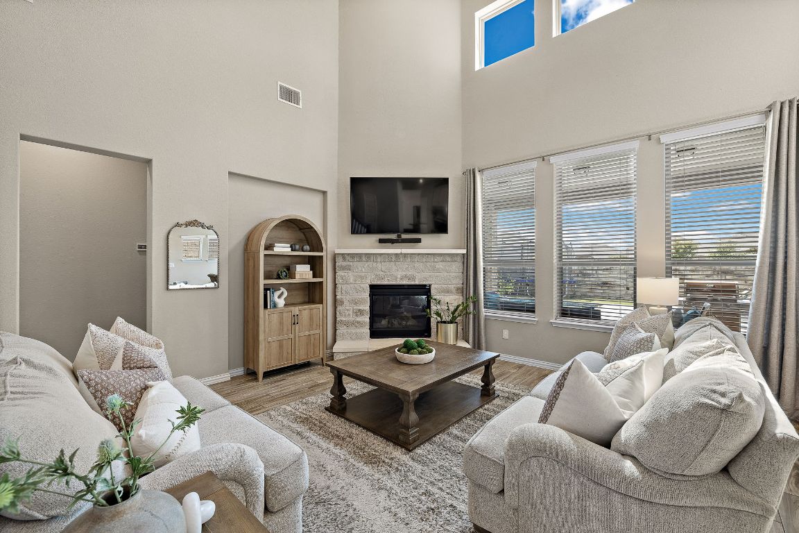 504 Leon Loop Liberty Hill, TX 78642 - Photo 6 of 40 a living room with furniture a flat screen tv and a fireplace